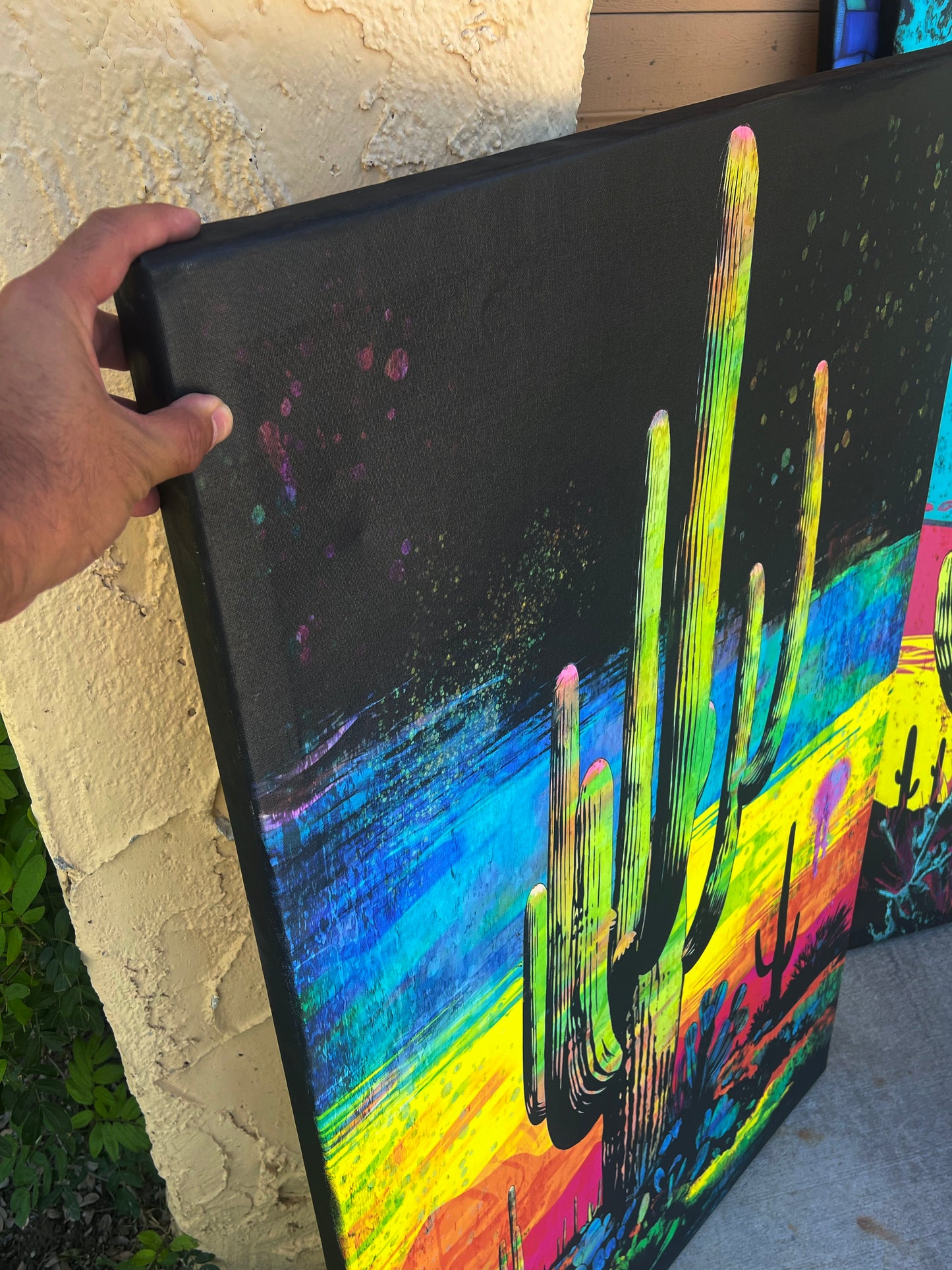 Colorful cactus painting held by a person outdoors. Colorful saguaro desert Arizona cactus painting brick wall art decor credenza 